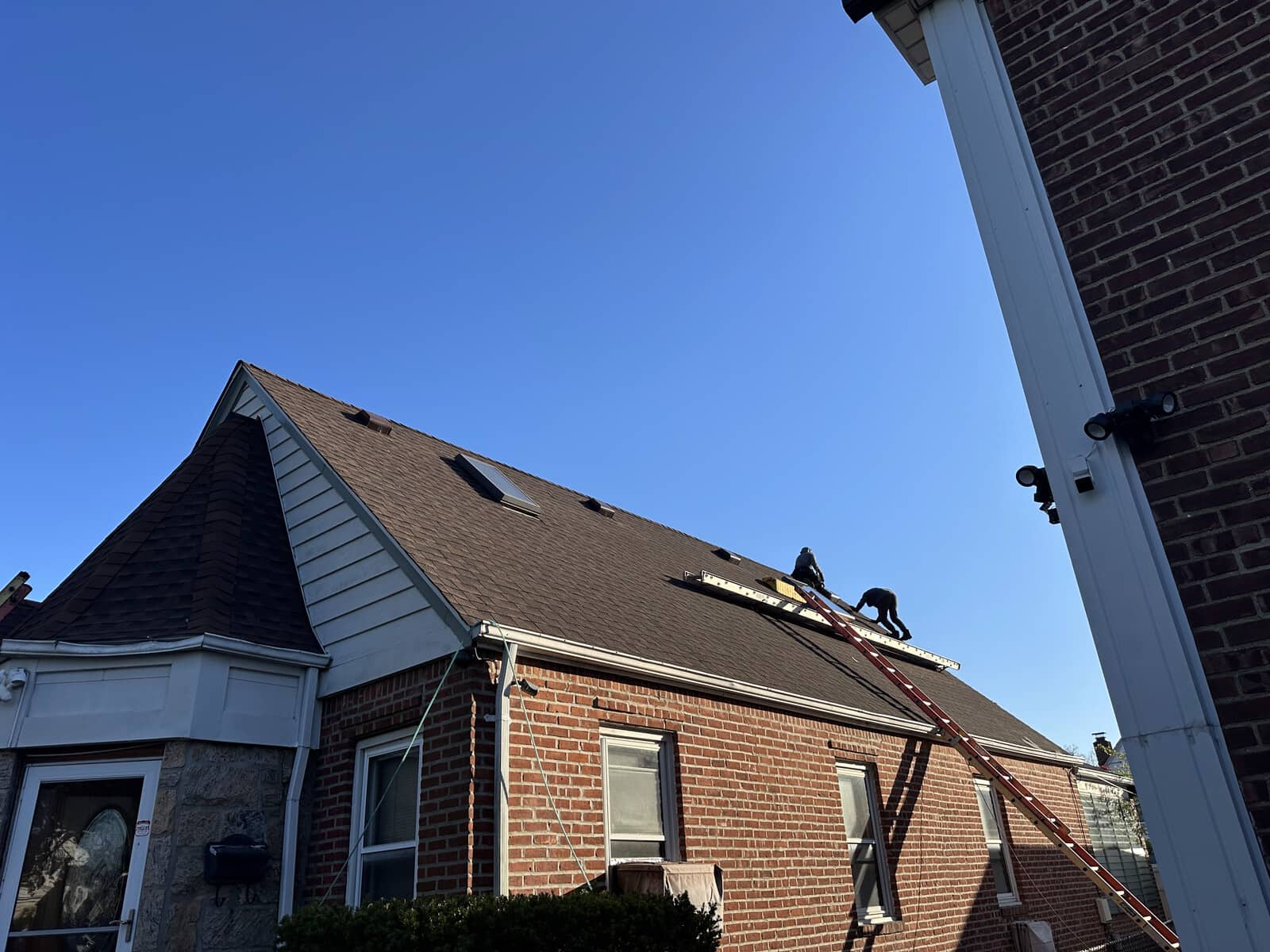 Roof repair crew working on brick colonial in Connecticut