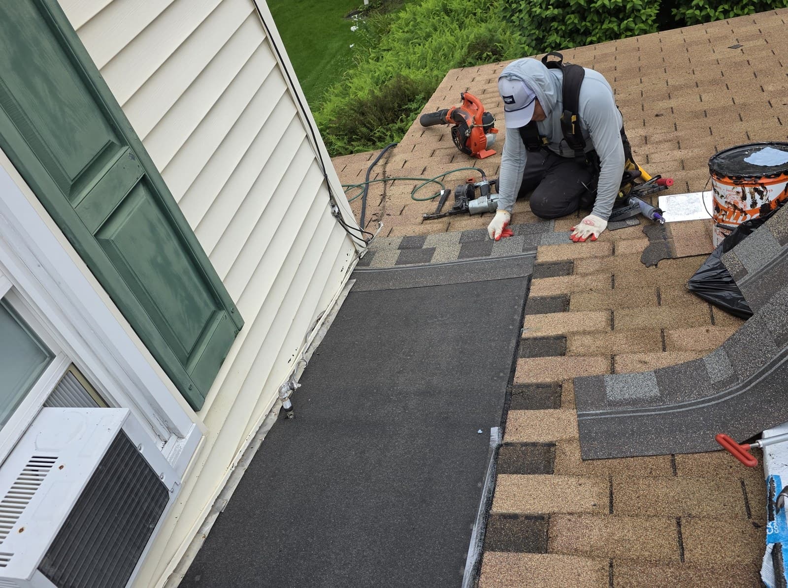 Membrane and shingles being installed at a roof-to-wall repair in Suffield, Connecticut