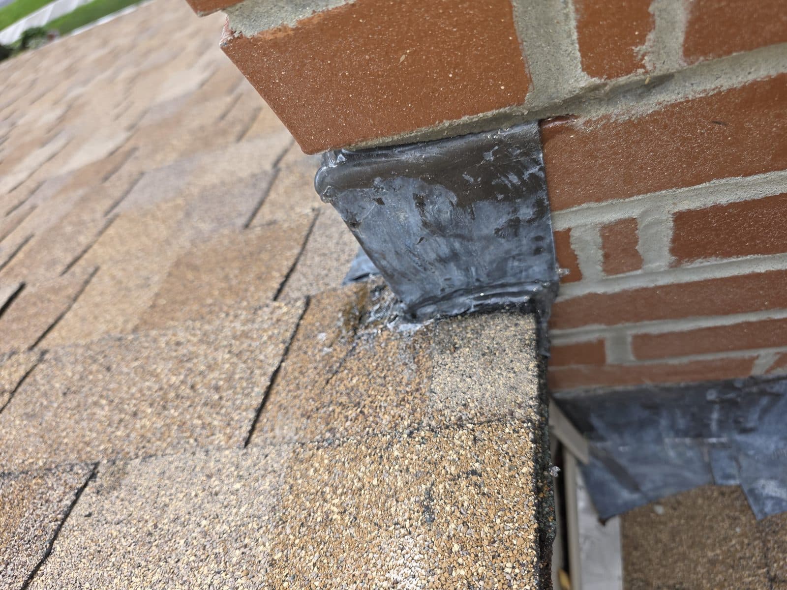 Chimney flashing corrected, pressed tight to the brick and sealed along the top and bottom edges.