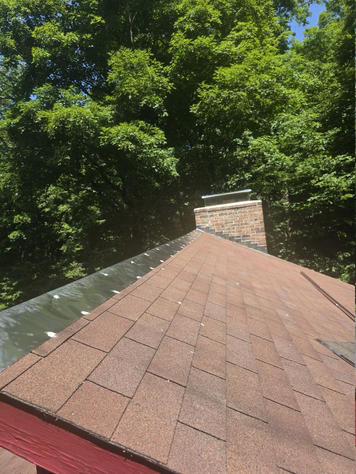 Red-brown shingles and sealed fasteners along a roof edge in Kent