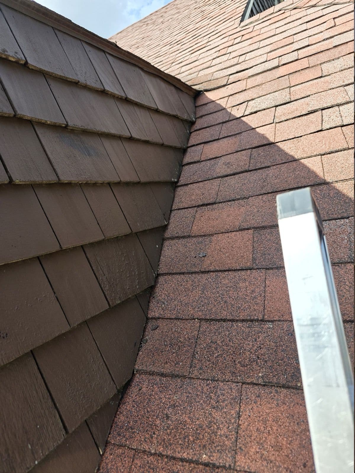 Red shingles along a completed roof-to-wall junction in New Britain