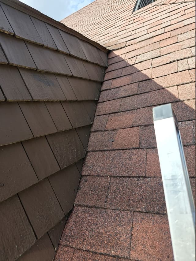 Red shingles along a completed roof-to-wall junction in New Britain