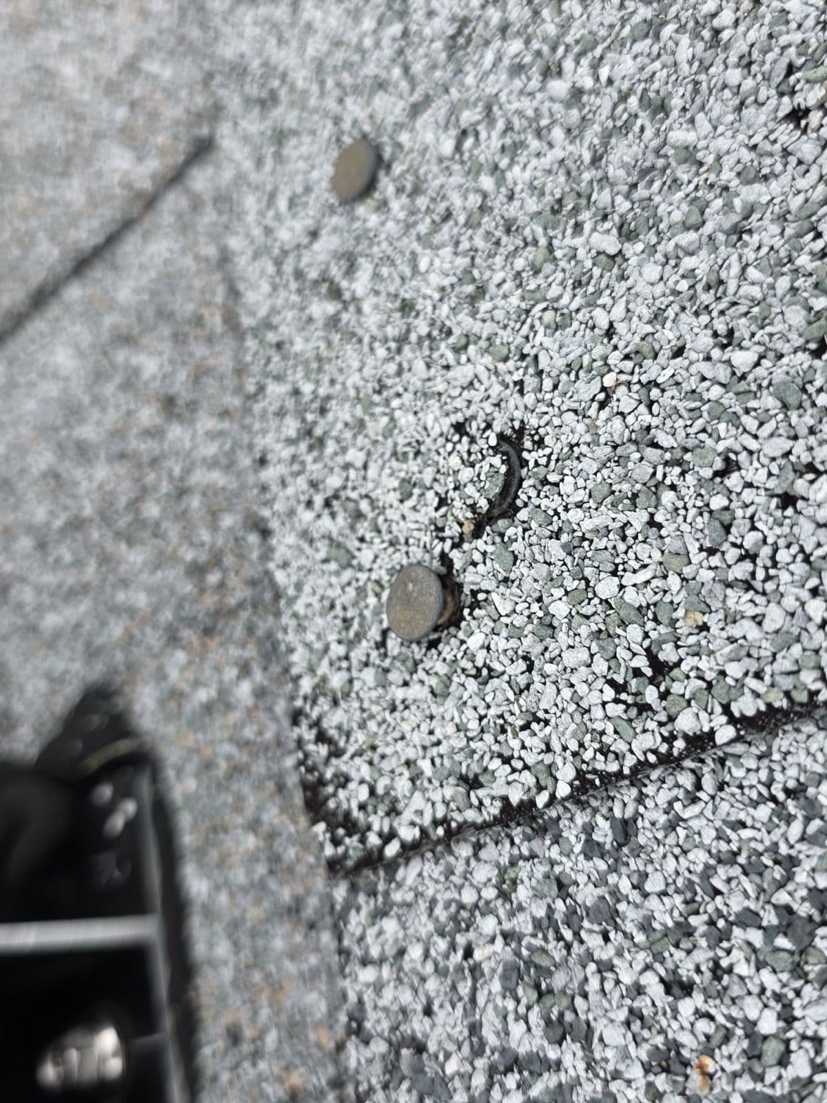 Exposed fastener heads beside a roof vent in Shelton