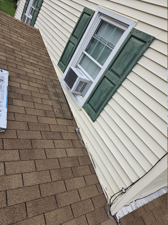 Existing shingle roof-to-wall junction before repair in Suffield