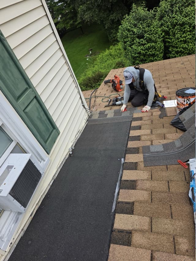 Membrane and shingles being installed beside a wall in Suffield