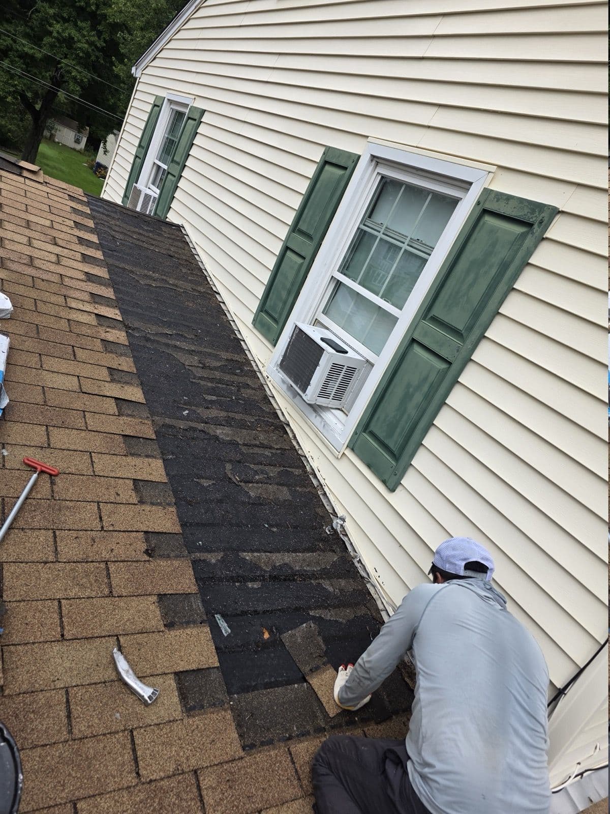 Crew member opening the shingle courses beside a wall in Suffield