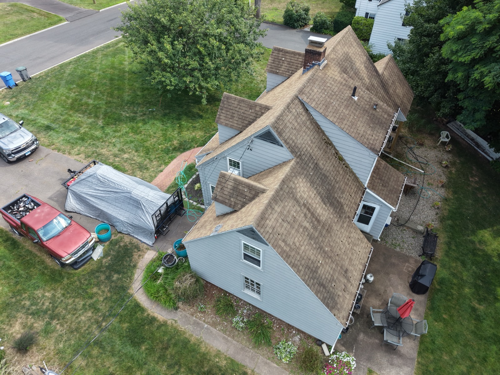 Aging complex multi-gable shingle roofline photographed by drone in Connecticut