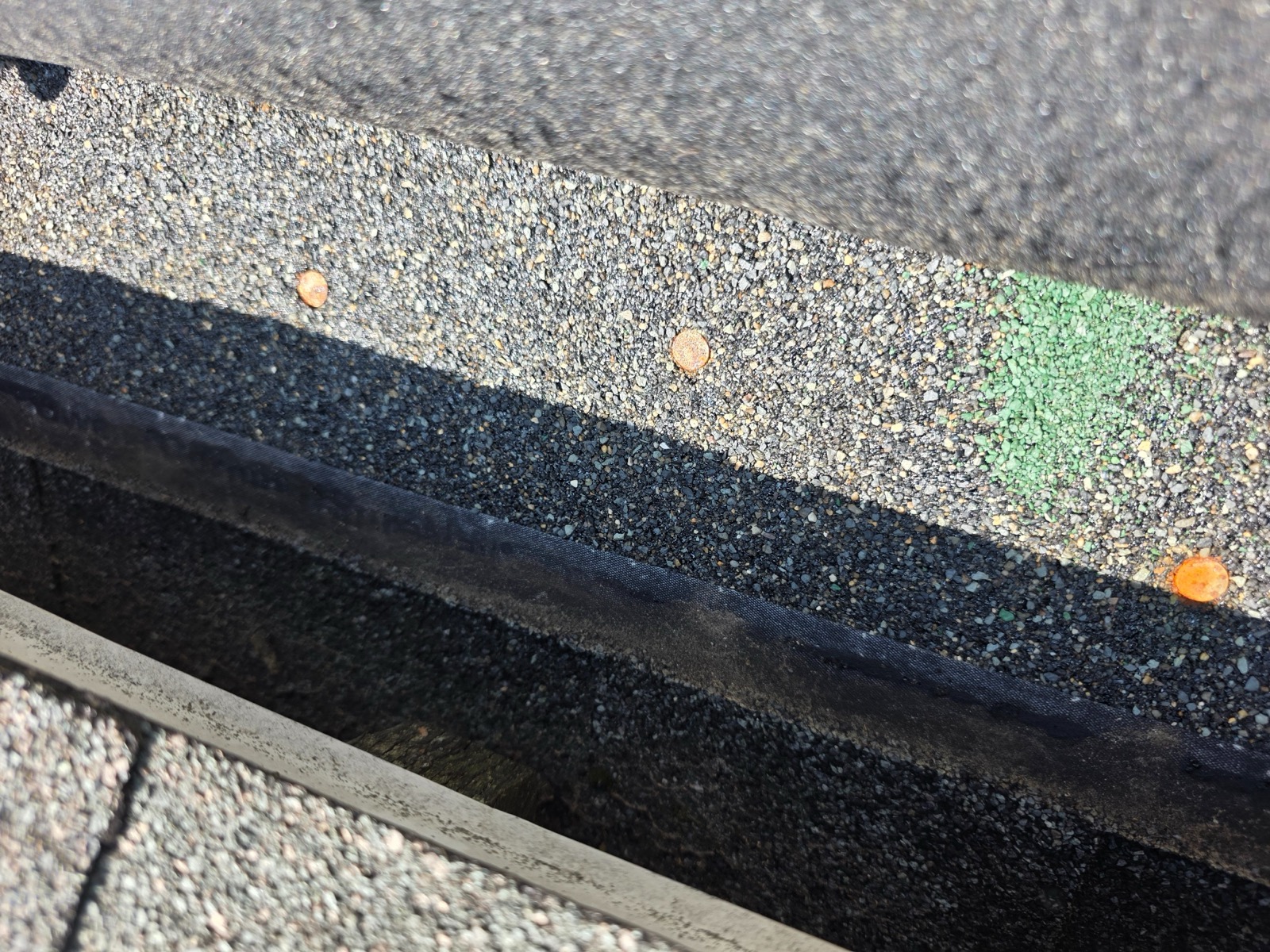 Overdriven nails cutting into shingles, a common cause of roof leaks found on a Suffield, CT inspection